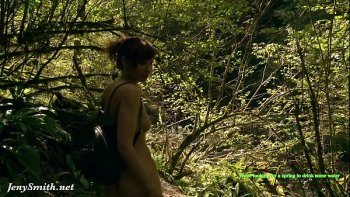 Загорелая рыжая девушка купается в море голая